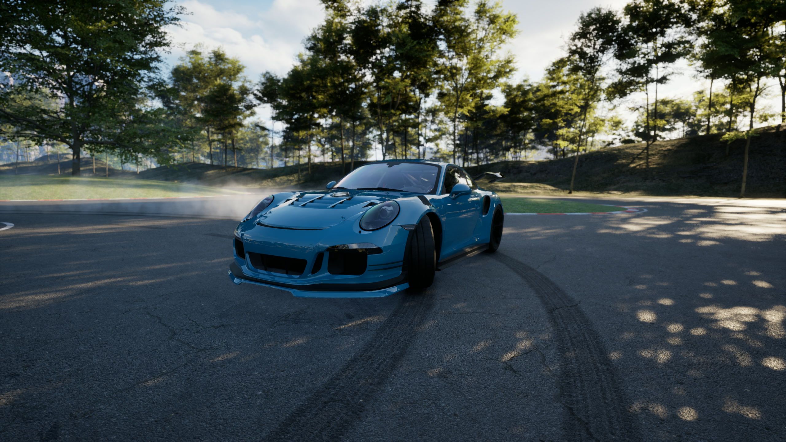 Teal car sliding toward the camera over fresh tire marks