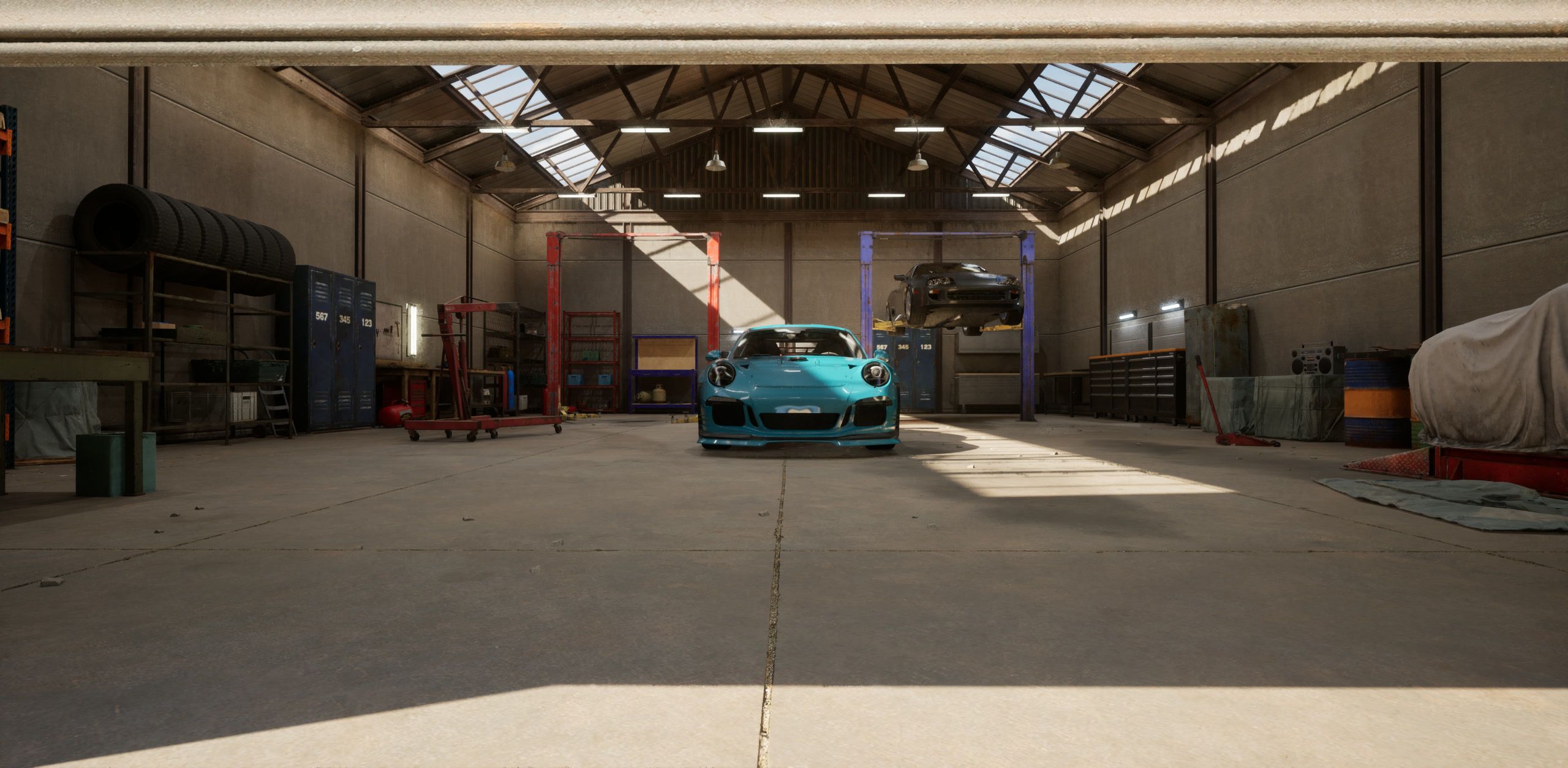 The World of Drift garage, with the teal car on the floor under the skylights and two cars on lifts
